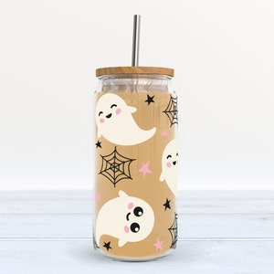 May include: A clear glass tumbler with a brown lid and a straw. The tumbler has a pattern of white ghosts, black spiderwebs, and pink stars on a tan background.