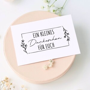 K&ouml;nnte beinhalten: Eine wei&szlig;e Karte mit schwarzem Text und einem schlichten Blumenmuster. Der Text lautet "EIN KLEINES Dankesch&ouml;n F&Uuml;R EUCH".