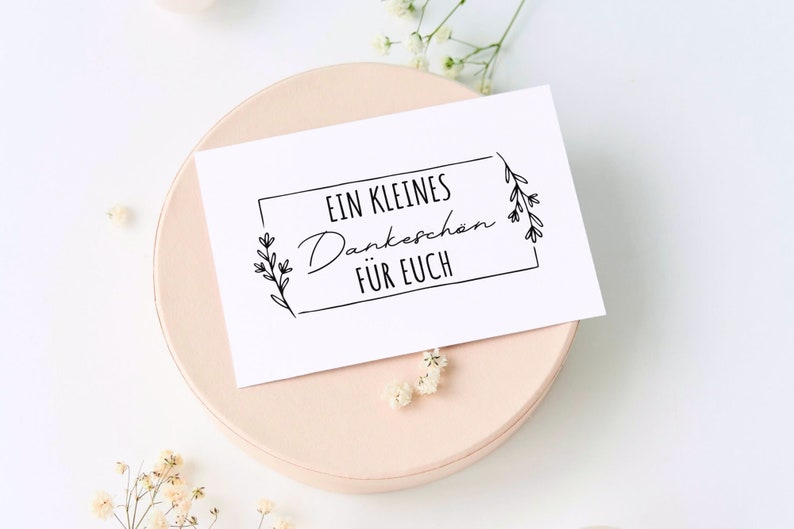 K&ouml;nnte beinhalten: Eine wei&szlig;e Karte mit schwarzem Text und einem schlichten Blumenmuster. Der Text lautet "EIN KLEINES Dankesch&ouml;n F&Uuml;R EUCH".