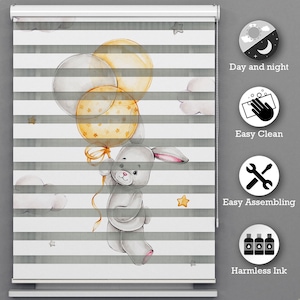 May include: A grey bunny holding yellow balloons with white stars printed on them. The bunny is flying against a white background with grey stripes and white clouds. The image is for a window blind.