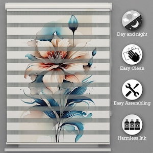 Op de afbeelding: Een wit en grijs zebra gestreept rolgordijn met een aquarel bloemenontwerp met een grote roze bloem en blauwe bladeren. Het gordijn wordt getoond met een kettingtrek en heeft een witte rand. De afbeelding bevat ook pictogrammen voor dag en nacht, gemakkelijk schoon te maken, gemakkelijk te monteren en onschadelijke inkt.