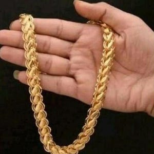 May include: A gold chain necklace with a unique, intricate design. The chain is made of small, linked pieces that resemble leaves.