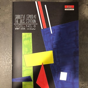 May include: A black and white zine with a geometric design in red, yellow, green, and blue. The title is "Should've Stayed at the Bus Station" and the subtitle is "Vol. No. 6 Harry Cook conductor".