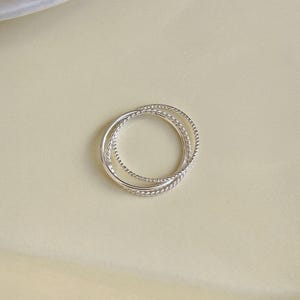 Lightweight trinity ring in sterling silver featuring three slim, contrasting bands fused in an elegant interwoven design.