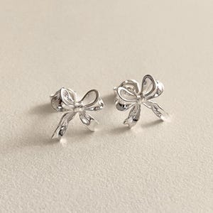 Silver bow shaped stud earrings