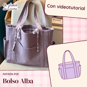 Puede incluir: Un bolso tote color lavanda con dos asas, bolsillos laterales y un cierre de lazo a cuadros vichy. El bolso tiene un forro interior a juego de cuadros vichy lavanda y blancos. El texto incluye El atelier de Laura, Con videotutorial y PATRÓN PDF Bolso Alba.