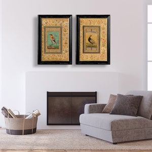 May include: Two framed prints of birds with intricate floral borders. The prints are in black frames with gold accents. The birds are depicted in a traditional style with vibrant colors.