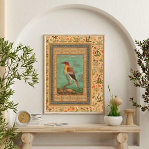 May include: A framed illustration of a colorful bird perched on a branch. The bird has red, yellow, and orange feathers. The frame is decorated with intricate floral patterns in shades of blue, green, and red.