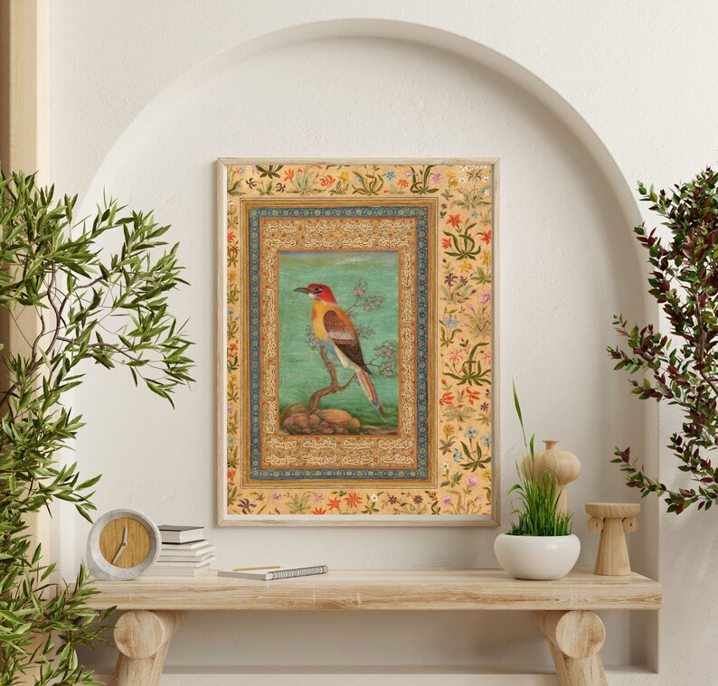 May include: A framed illustration of a colorful bird perched on a branch. The bird has red, yellow, and orange feathers. The frame is decorated with intricate floral patterns in shades of blue, green, and red.