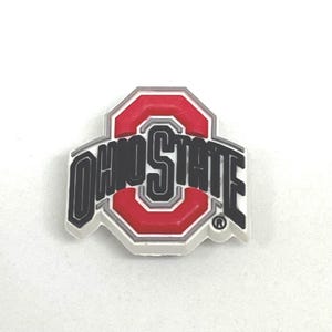 May include: A white, red, and black Ohio State logo. The logo features a red block O with the words "OHIO STATE" in black lettering. The logo has a white border and a gray outline.