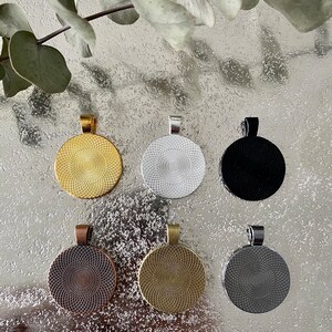K&ouml;nnte beinhalten: Sechs runde Metall-Anh&auml;nger-Rohlinge in verschiedenen Farben: Gold, Silber, Schwarz, Kupfer, Antik-Gold und Silber. Jeder Rohling hat ein erhabenes kreisf&ouml;rmiges Design.