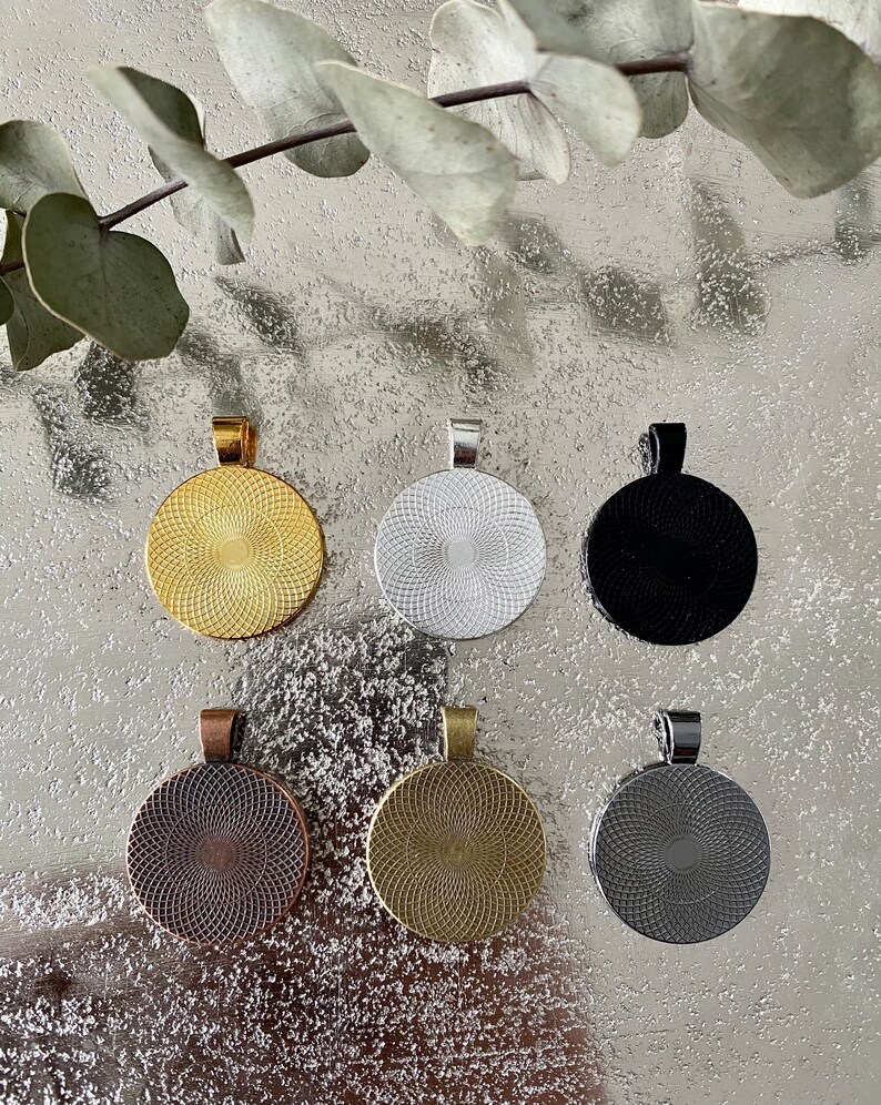 K&ouml;nnte beinhalten: Sechs runde Metall-Anh&auml;nger-Rohlinge in verschiedenen Farben: Gold, Silber, Schwarz, Kupfer, Antik-Gold und Silber. Jeder Rohling hat ein erhabenes kreisf&ouml;rmiges Design.