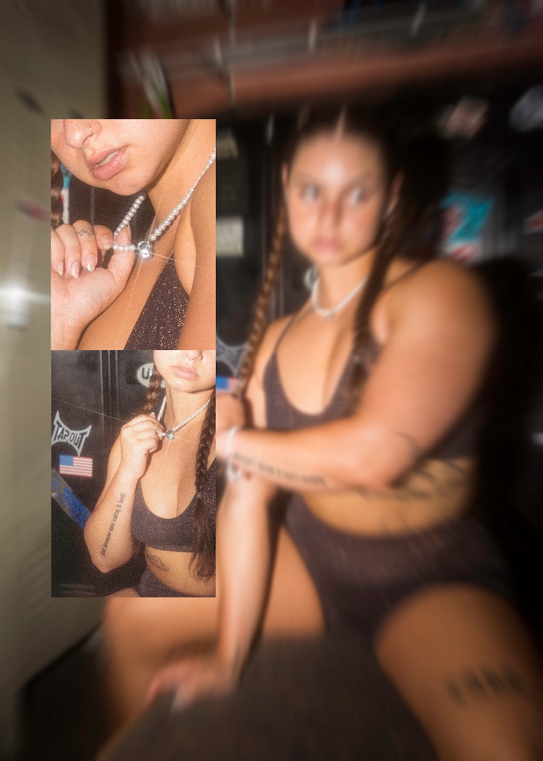 May include: A black sports bra and shorts set. The model is wearing a pearl necklace with a silver pendant. The image has a blurred effect. The model has long braids and tattoos on their arms.