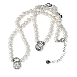 May include: A white pearl necklace with two silver-toned kettlebell pendants, each featuring a clear crystal. The necklace has a silver clasp and an extender chain. The pendants have a small, stylized "S" logo.