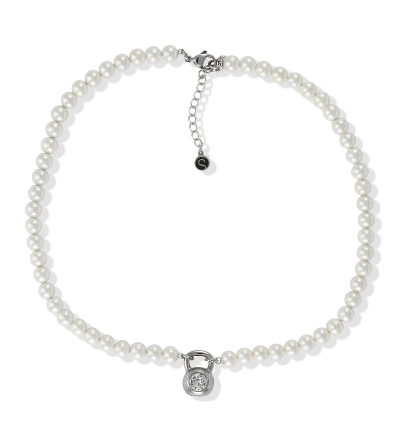 May include: A white pearl necklace with a silver-toned clasp and a pendant. The pendant is a small, silver-toned kettlebell shape with a clear, round gemstone in the center. The necklace is on a white background.