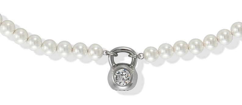 May include: A pearl necklace with a silver-colored kettlebell pendant. The pendant features a clear, round gemstone. The necklace is composed of numerous white pearls, creating a classic and elegant look.