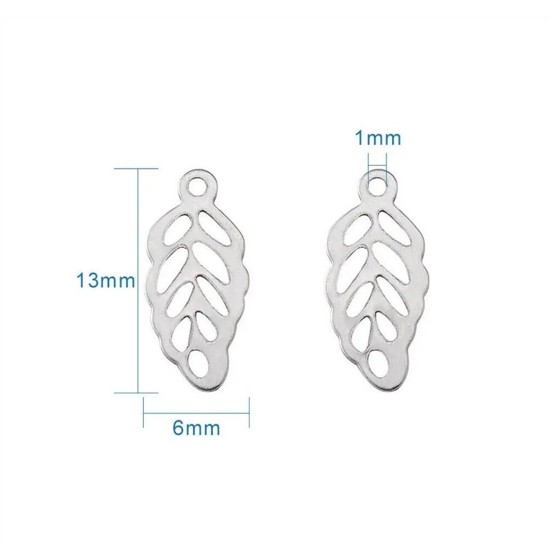 May include: Two silver leaf-shaped charms with a cutout design. Each charm measures 13 mm in length, 6 mm in width, and 1 mm in thickness.