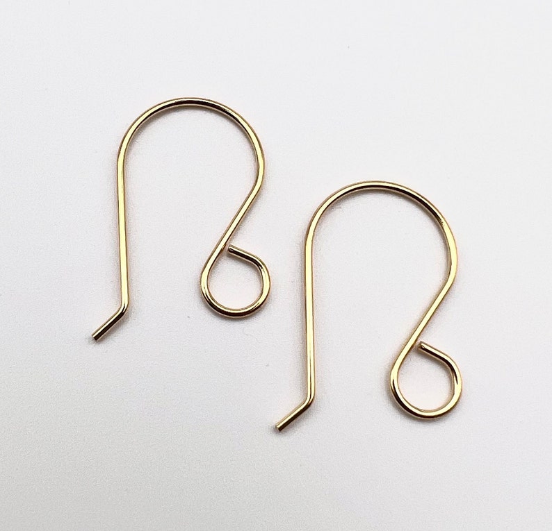 May include: A pair of gold-toned earring hooks. The hooks are made of metal and have a simple, elegant design.