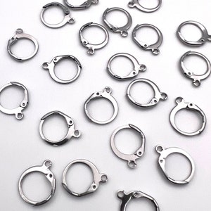 May include: A collection of silver-toned earring hooks, also known as earring findings, for jewelry making. These hooks are designed to be used with a variety of earring styles.