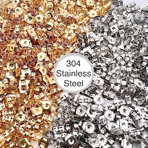 May include: A large quantity of gold and silver earring backs made of 304 stainless steel. The earring backs are in a pile and are ready to be used for jewelry making.