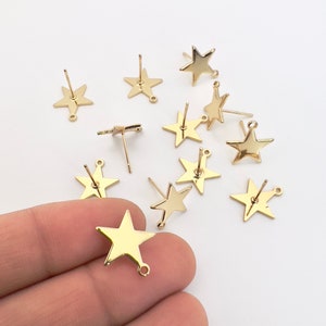 May include: Gold-colored star-shaped earring posts with a post and loop design. The earrings are shiny and have a smooth surface. The image shows several individual earring components, ideal for jewelry making or crafting.