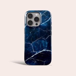 May include: A smartphone case with a dark blue marble effect. The case has a glossy finish and white veining. The camera lenses are visible at the top. The case is designed to fit a smartphone.