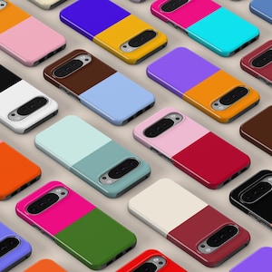 Op de afbeelding: Een verzameling smartphonehoesjes gerangschikt in een rasterpatroon, elk met een tweekleurig kleurblokontwerp. De hoesjes tonen verschillende levendige en neutrale kleurencombinaties, waaronder oranje, roze, blauw, geel, zwart en wit.