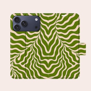 Può includere: Custodia per telefono con motivo verde e beige. La custodia presenta un motivo a onde ripetuto in tonalità verdi e beige. La custodia ha una chiusura magnetica e un ritaglio per la fotocamera.