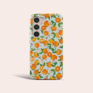 以下が含まれることがあります： 薄い青色の背景にオレンジのスライスと白い花のパターンが描かれた携帯電話ケースです。
