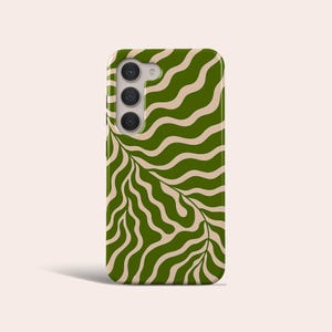 Può includere: Custodia per telefono con un motivo ondulato verde e beige. La custodia ha un modulo fotocamera con tre obiettivi. Il design presenta un motivo ripetuto di linee curve e forme simili a foglie, creando un'estetica moderna e astratta.