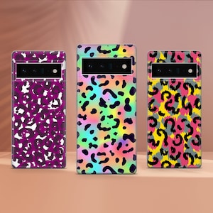 May include: Three phone cases with colorful leopard print designs. The cases feature a camera cutout and are in shades of purple, rainbow, and yellow. The leopard spots are black, white, and gray.