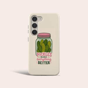 May include: A cream-coloured smartphone case featuring a graphic of a glass jar filled with green pickles and a pink lid. Below the jar, the text reads PICKLES MAKE everything BETTER in a combination of pink and dark green stylised lettering.