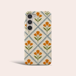 May include: A phone case with a repeating floral pattern. The design features orange tulip-like flowers, green stems, and blue-green leafy vines on a cream background. The case has a camera module with three lenses.