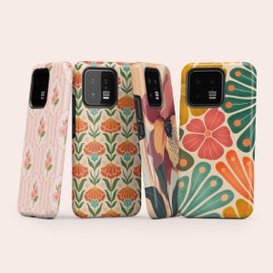 Könnte beinhalten: Vier rechteckige Smartphone-Hüllen mit unterschiedlichen Blumenmustern. Die erste zeigt rosa Blüten auf Streifen, die zweite orangefarbene und blaugrüne botanische Motive, die dritte eine große einzelne Blume und die vierte ein kräftiges Blütenblattdesign.