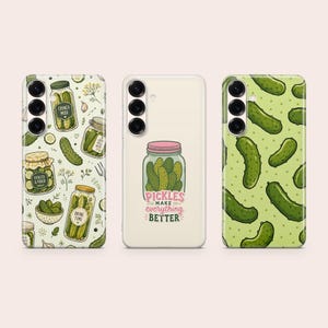 May include: Three phone cases featuring pickle-themed designs. The left case has a pattern of pickle jars and dill. The centre case is cream-coloured with a single jar and the text Pickles Make Everything Better. The right case has a green polka dot pattern.