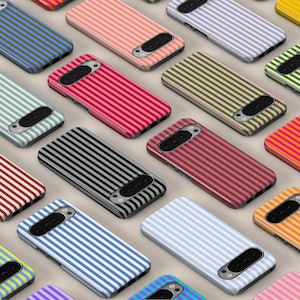Op de afbeelding: Een verzameling rechthoekige smartphonehoesjes gerangschikt in een rasterpatroon. Elk hoesje heeft een opvallend tweekleurig verticaal streeppatroon in diverse kleurcombinaties, waaronder rood, blauw, groen, geel, oranje, roze en zwart.