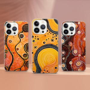 May include: Three iPhone cases with an Australian Aboriginal art design. The cases are black, orange, and yellow with intricate patterns.
