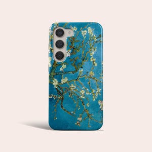 Puede incluir: Una funda de teléfono azul con un diseño floral blanco y amarillo. El diseño recuerda a una pintura de Vincent van Gogh.