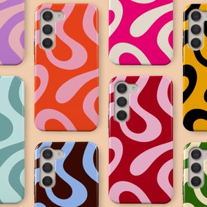 May include: A selection of mobile phone cases with abstract, swirling patterns. The cases display bright colours including orange, pink, red, blue, and yellow, giving a retro, groovy appearance. Each case has a camera aperture and button placements.