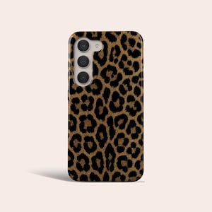May include: A smartphone case featuring a brown and black leopard print pattern. The case has a camera module with three lenses. The case is rectangular with rounded corners.