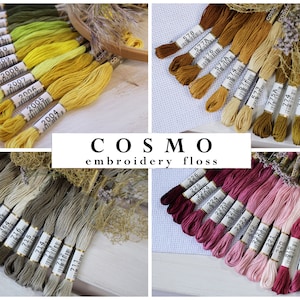 May include: Assortment of embroidery floss in various shades of yellow, green, brown, beige, pink, and red. The floss is arranged in rows and labeled with numbers. The text "COSMO embroidery floss" is displayed in the center of the image.