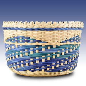 May include: A woven basket with a blue and green pattern. The basket is made of natural materials and has a round shape.