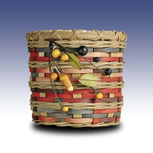 May include: A woven basket with a red, gray, and beige pattern. The basket is decorated with a sprig of faux leaves and berries.