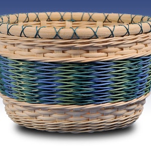 May include: A woven basket with a natural brown color and a blue and green woven band around the middle.