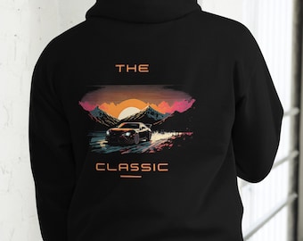 May include: Black hooded sweatshirt with a graphic print of a car driving through a mountain landscape at sunset. The text "THE CLASSIC" is printed below the image.