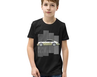 Puede incluir: Camiseta negra para niños con un gráfico de coche Porsche 911 blanco y el texto "Nine Eleven" en gris.