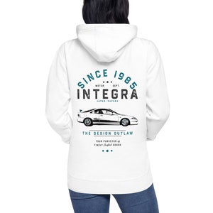 Könnte beinhalten: Weißer Kapuzenpullover mit einem blauen und schwarzen Grafikdruck eines Autos mit dem Text "SINCE 1985 MOTOR DEPT. INTEGRA JAPAN SUZUKA THE DESIGN OUTLAW YOUR PURVEYOR of FINELY GOODS..."