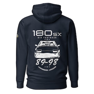 May include: A navy blue hoodie with a white graphic of a 180SX S13 Fastback car. The graphic also includes the text "180SX", "S13 FASTBACK", "89-98", and "JAPANESE: LEGEND".