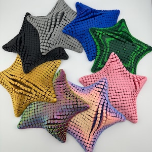 May include: A collection of colorful, textured starfish in various shades, including black, gray, blue, green, pink, gold, and iridescent. Each starfish has a unique pattern and is arranged in a circular pattern against a white background.