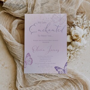 Op de afbeelding: Een paarse en witte babyborrel uitnodiging met een vlinderontwerp. De uitnodiging luidt "We are Enchanted To Meet You..." en bevat details over het evenement, inclusief de datum, tijd, locatie en RSVP-informatie.